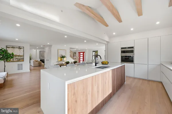 a large kitchen with stainless steel appliances kitchen island a large counter top and a view of living room
