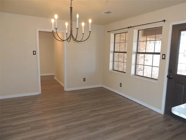 a view of a room with wooden floor and windows