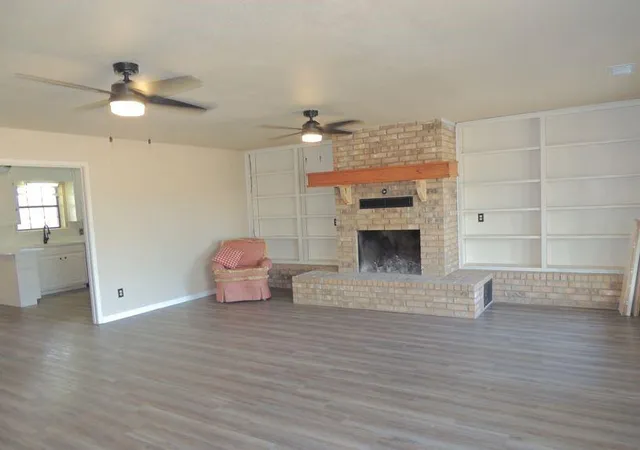 a view of a livingroom with wooden floor and a ceiling fan