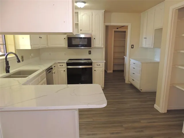 a kitchen with stainless steel appliances a sink dishwasher stove refrigerator and microwave