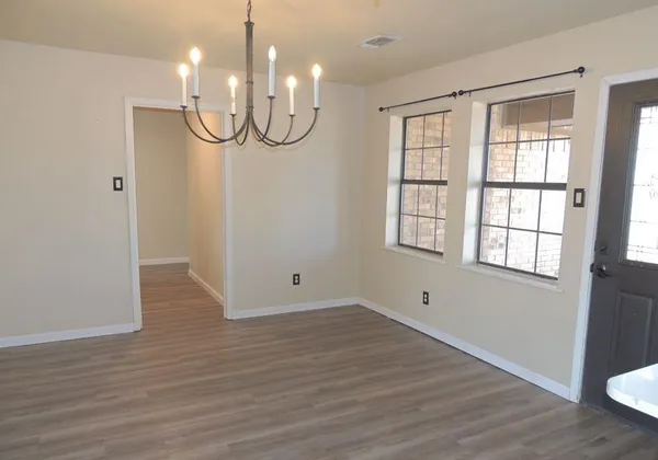 a view of a room with wooden floor and window
