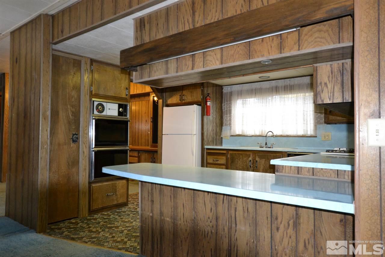 16055 Rhyolite Circle Reno, NV 89521 - Photo 5 of 23 a kitchen with stainless steel appliances kitchen island granite countertop a refrigerator and a sink