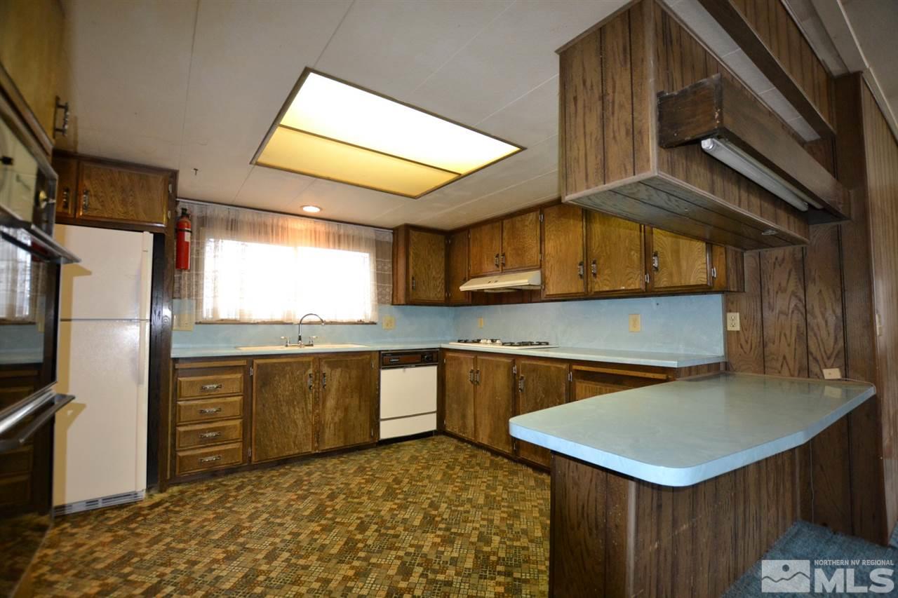 16055 Rhyolite Circle Reno, NV 89521 - Photo 7 of 23 a kitchen with stainless steel appliances granite countertop a sink a stove counter space and cabinets