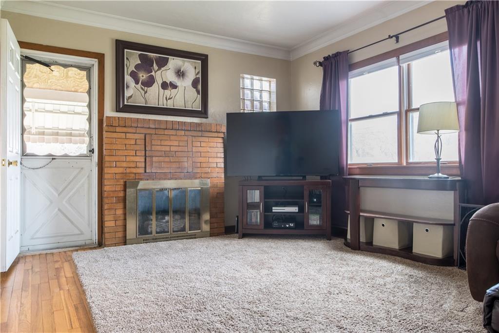 922 Agnew Road Pittsburgh, PA 15227 - Photo 3 of 19 Bright and clean living room features a gas fireplace, hardwood flooring and crown molding. Access to the covered side porch.