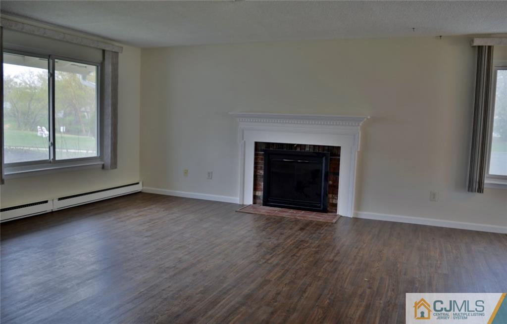 40 A Haddon Road Monroe Township, NJ 08831 - Photo 2 of 11 an empty room with wooden floor fireplace and windows