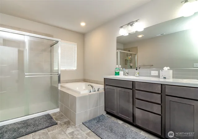 a bathroom with a sink double vanity granite tub and shower