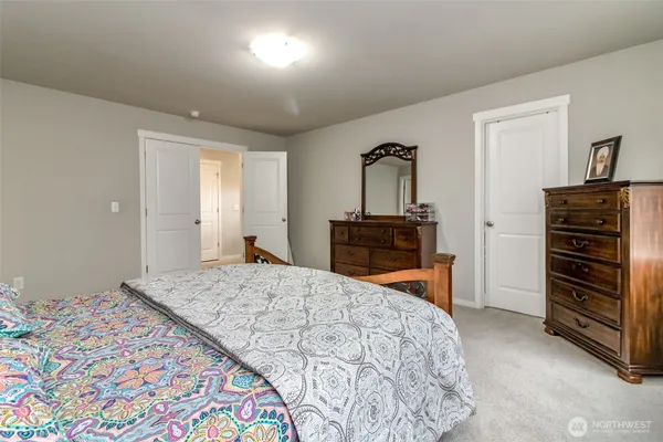 a bedroom with a bed and a dresser in it
