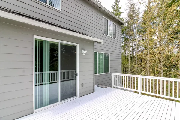 a porch with a wooden floor and a yard