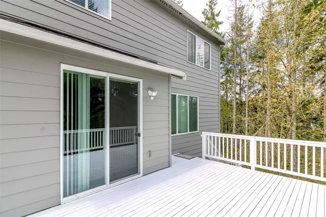 a porch with a wooden floor and a yard