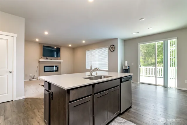 a kitchen with a sink and a stove top oven with wooden floor