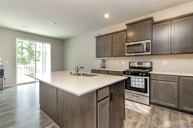a kitchen with a sink stove and microwave