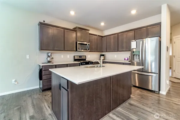 a kitchen with kitchen island a sink stainless steel appliances and cabinets