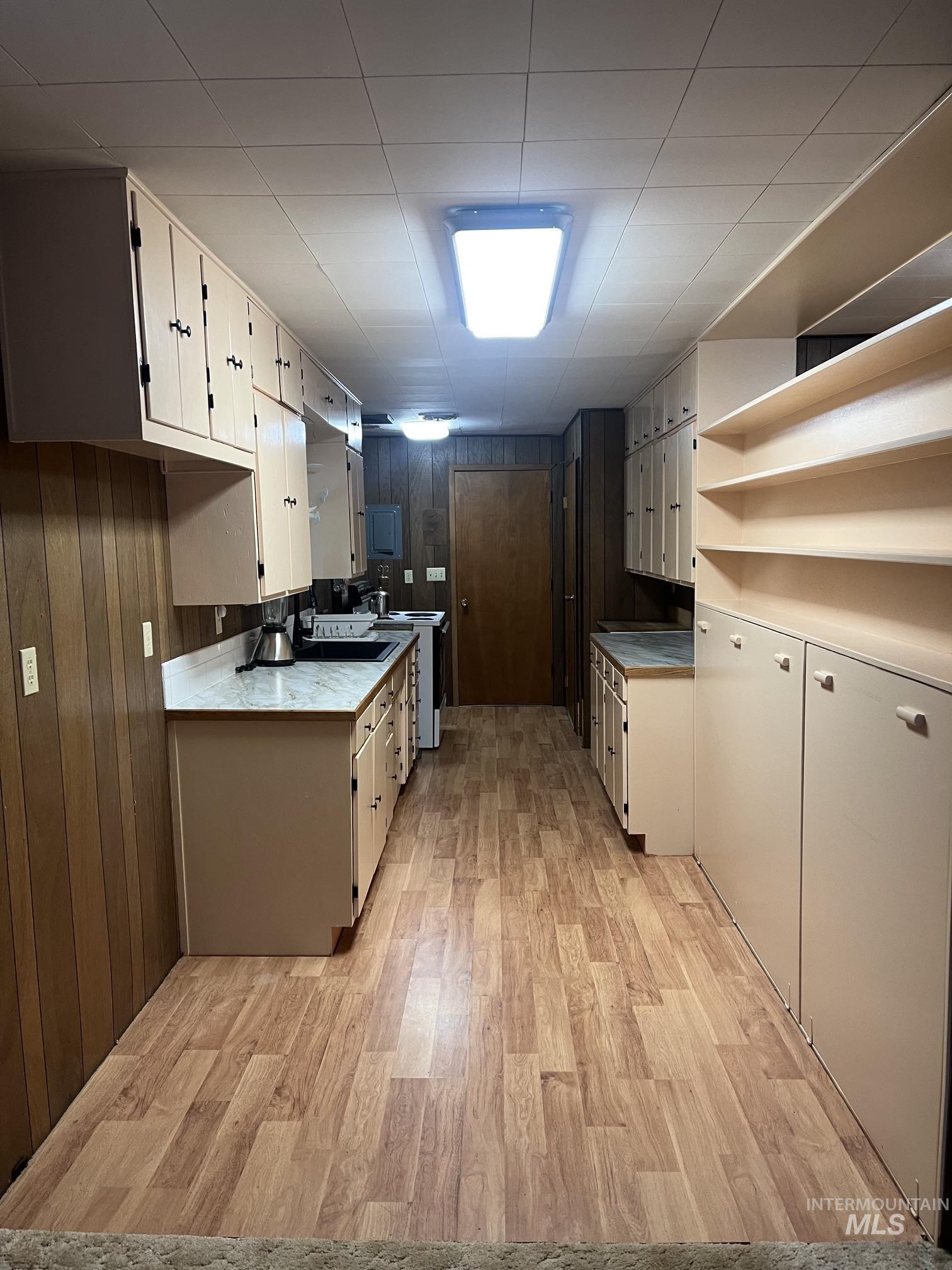 39 Mayflower Mine Road Placerville, ID 83666 - Photo 27 of 36 Galley kitchen featuring extensive cabinetry, wood-finish flooring, light-colored countertops, and ceiling-mounted lighting