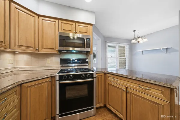 a kitchen with granite countertop cabinets stainless steel appliances and a sink