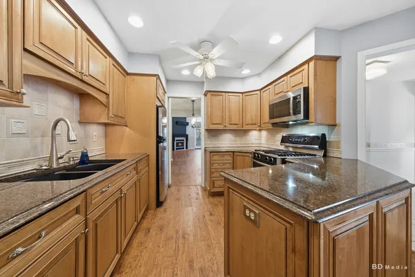 a kitchen with stainless steel appliances granite countertop a sink stove and refrigerator