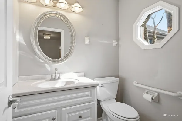 a bathroom with a toilet a sink and mirror