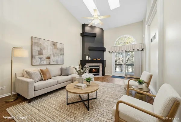 a living room with furniture a fireplace and a chandelier