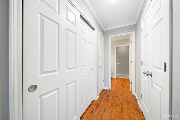a view of a hallway with wooden floor and staircase