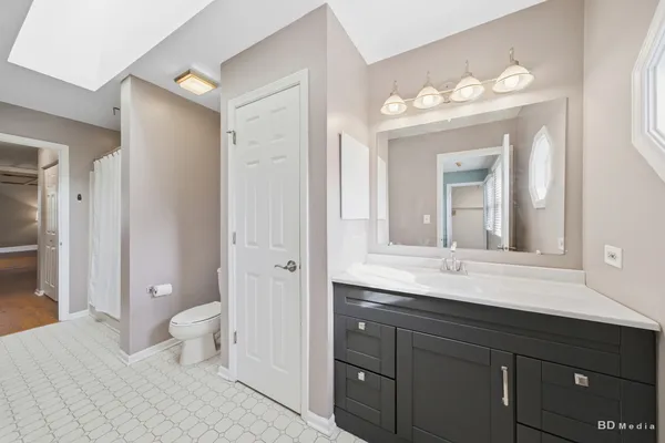 a bathroom with a sink a toilet and a large mirror