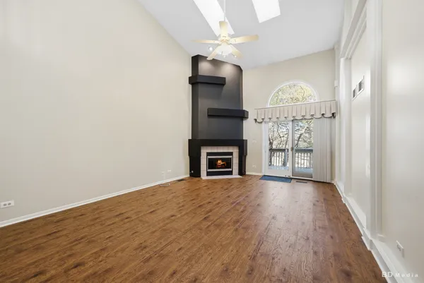 a view of empty room with wooden floor and fireplace