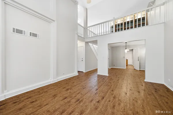 a view of a big room with wooden floor and windows