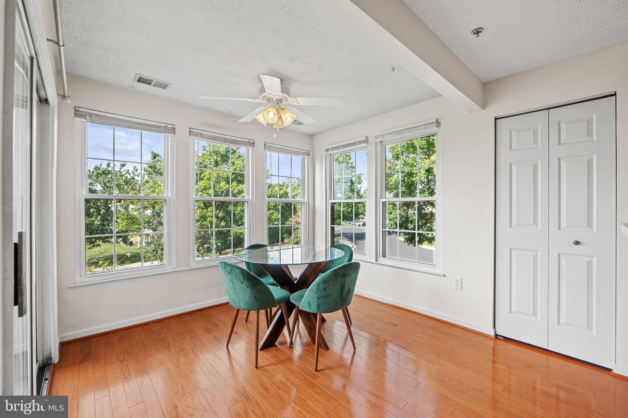 699 Winding Stream Way, Unit 203 Odenton, MD 21113 - Photo 14 of 41 a dining room with wooden floor a chandelier a glass table and chairs