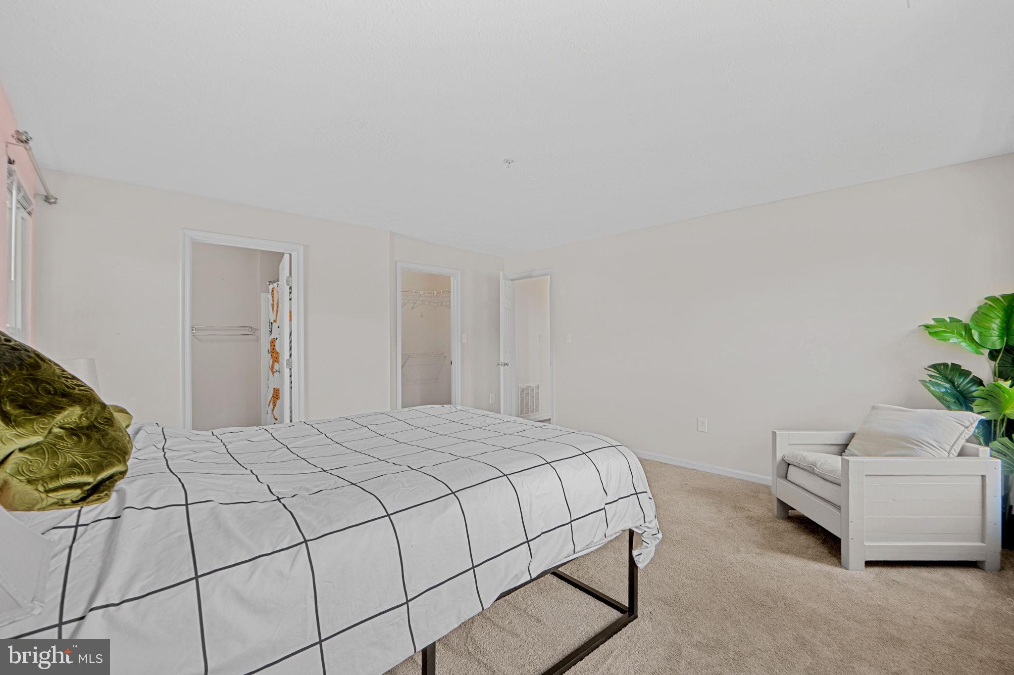 699 Winding Stream Way, Unit 203 Odenton, MD 21113 - Photo 22 of 41 a bedroom with a bed and a potted plant
