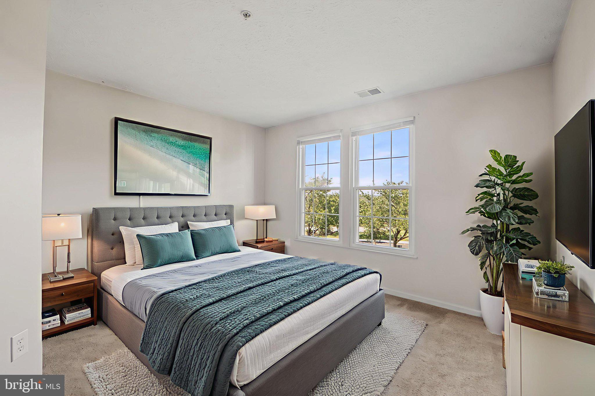 699 Winding Stream Way, Unit 203 Odenton, MD 21113 - Photo 9 of 41 a bedroom with a bed and a potted plant