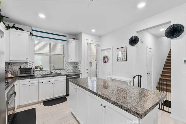 a kitchen with granite countertop a sink and a stove