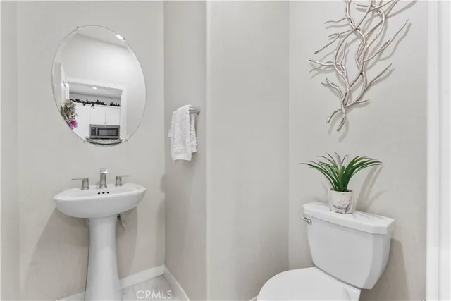 a bathroom with a sink toilet and a mirror