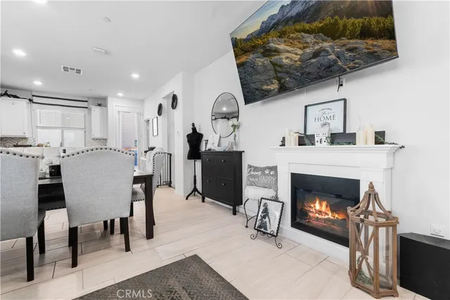 a living room with furniture a fireplace and kitchen view