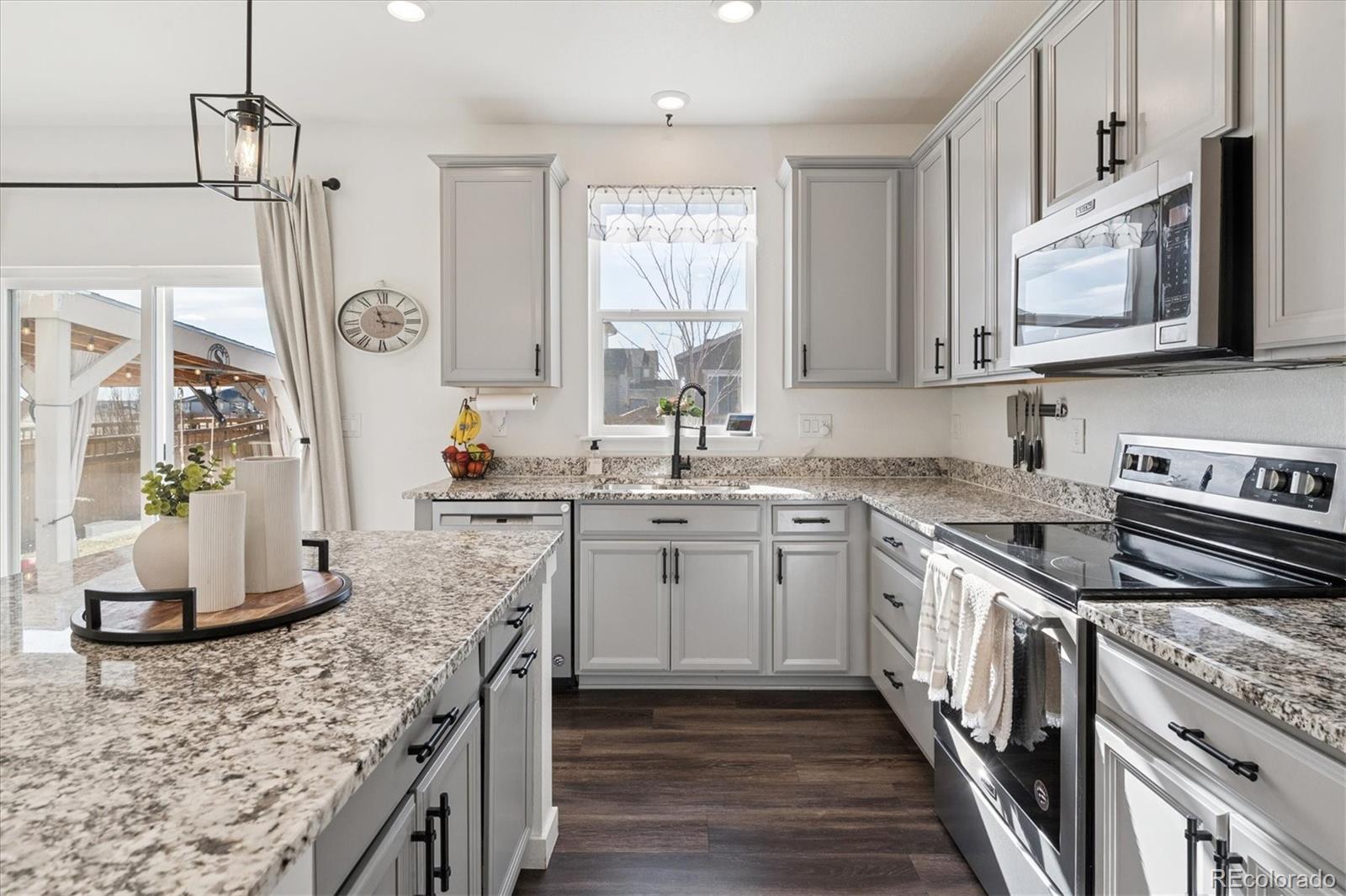 3530 Sawtooth Street Frederick, CO 80516 - Photo 12 of 36 a kitchen with stainless steel appliances granite countertop a stove a sink and a microwave