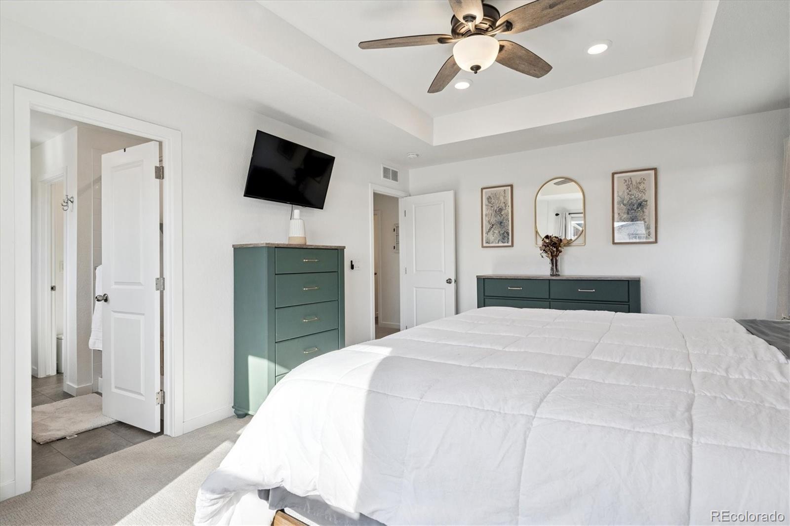 3530 Sawtooth Street Frederick, CO 80516 - Photo 16 of 36 a bedroom with a bed and a flat screen tv