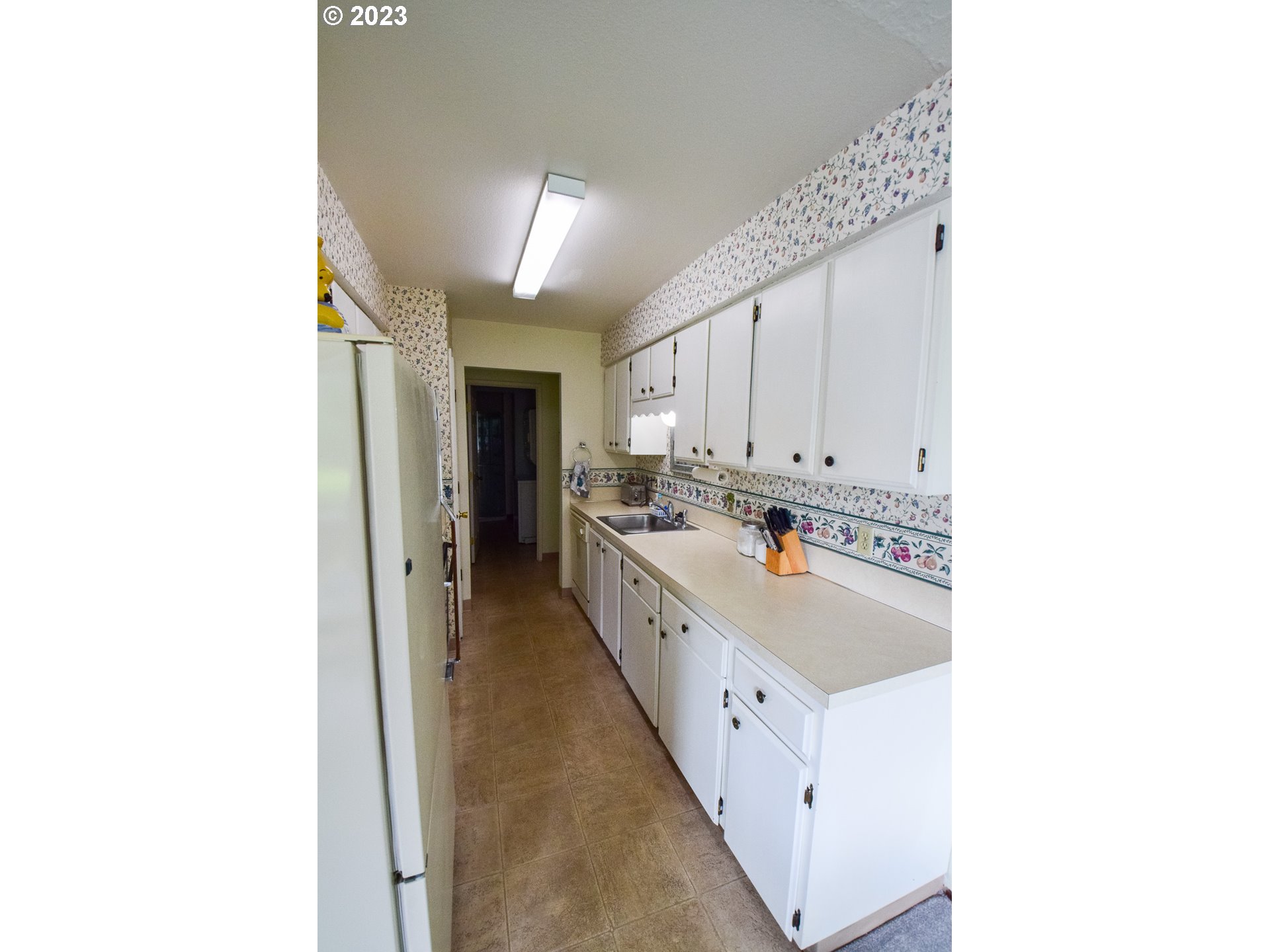 950 Evergreen Road, Unit 122 Woodburn, OR 97071 - Photo 5 of 20 a large white kitchen with kitchen island a sink a stove and a refrigerator