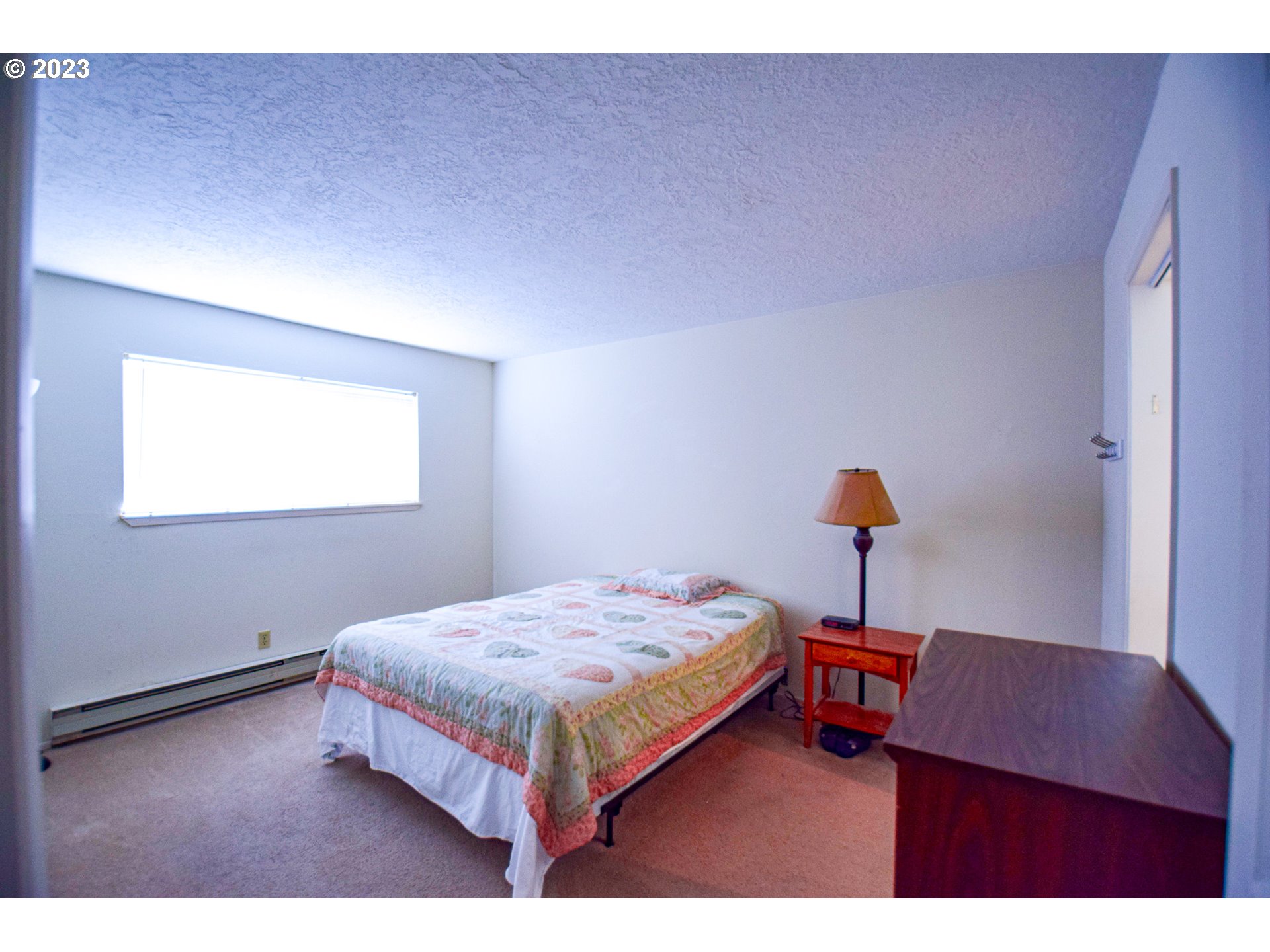 950 Evergreen Road, Unit 122 Woodburn, OR 97071 - Photo 7 of 20 a bedroom with a bed and a lamp