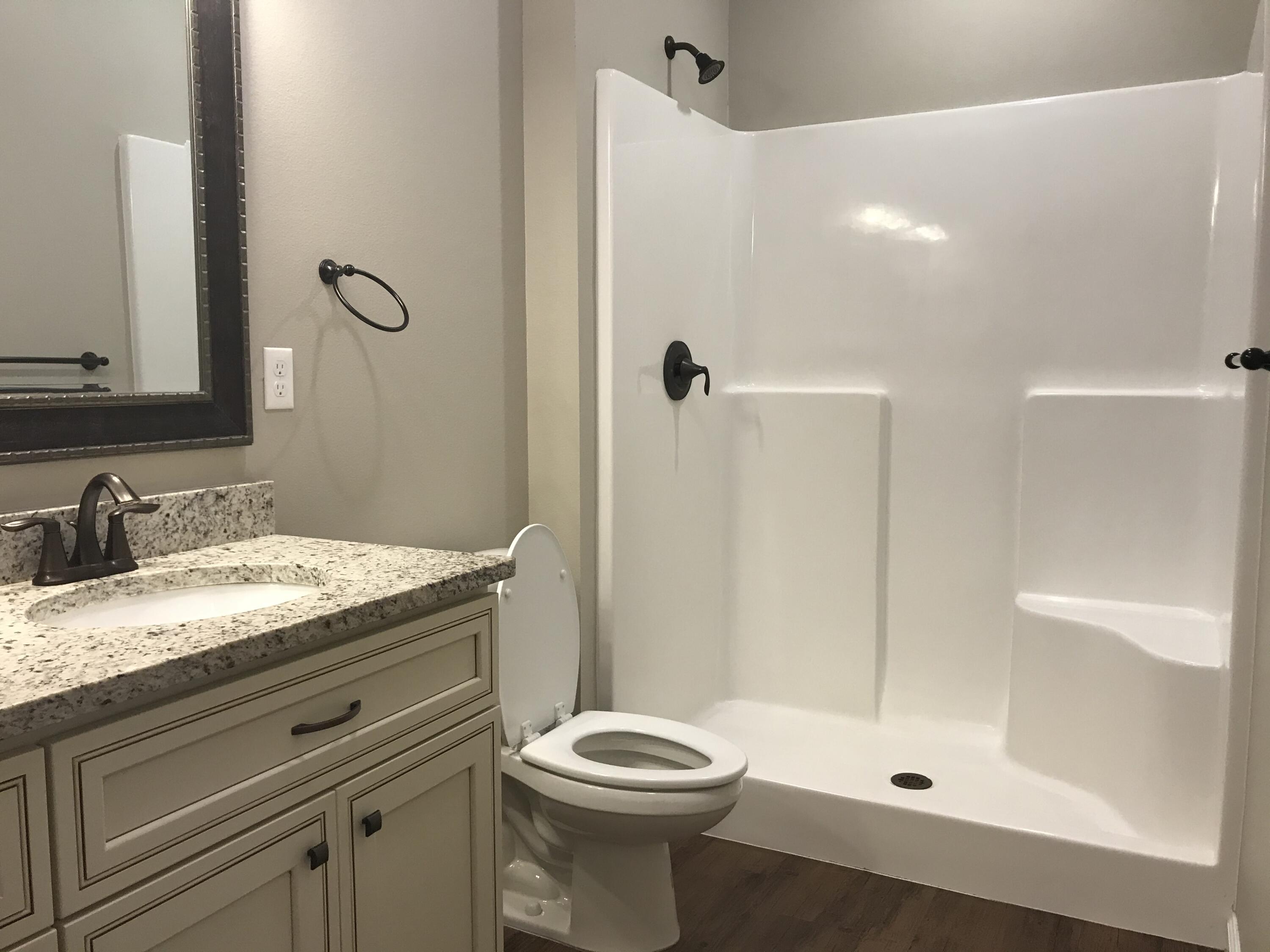 240 Dixie Street Crestview, FL 32536 - Photo 12 of 20 a bathroom with a granite countertop sink toilet and shower