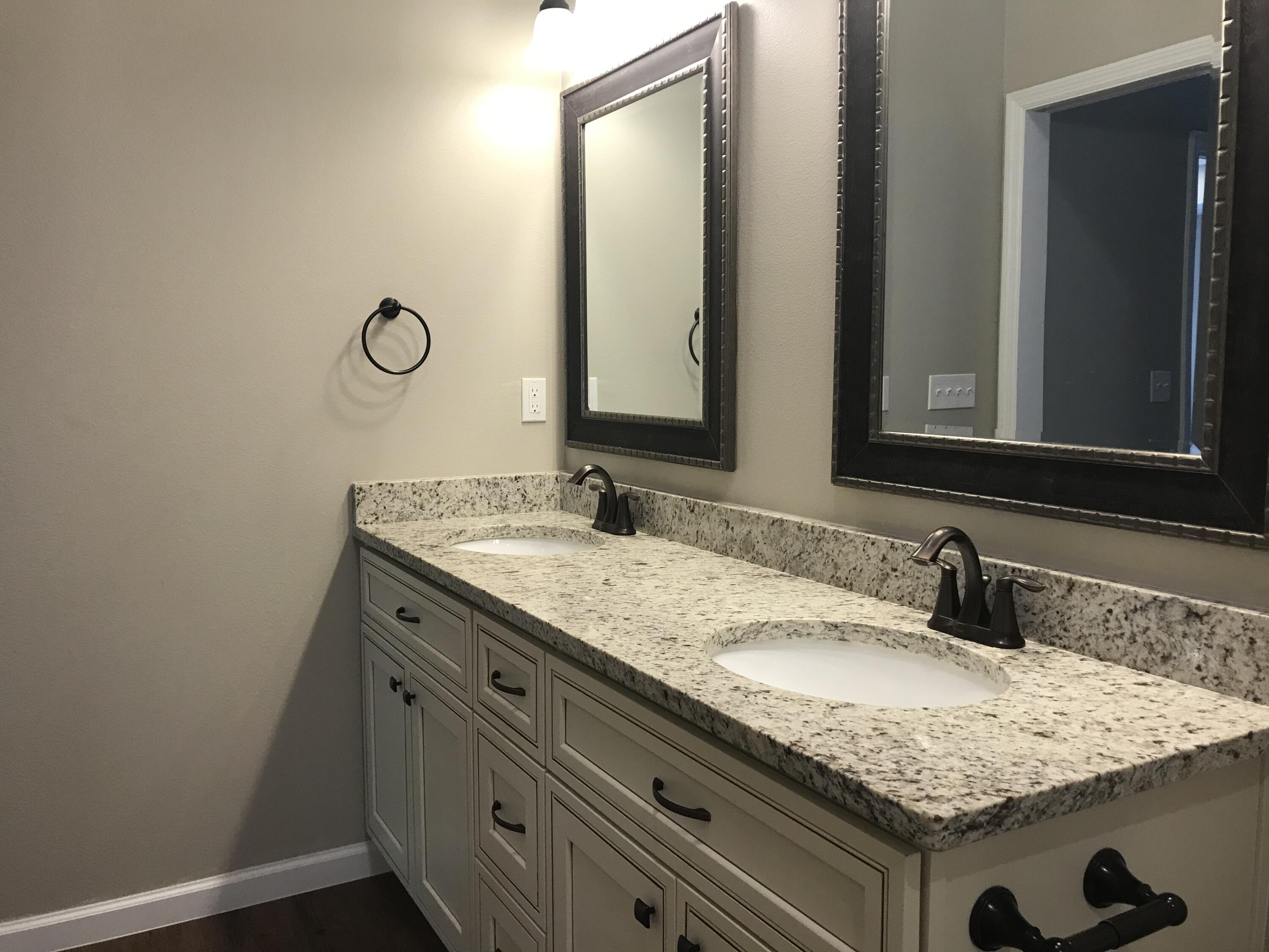240 Dixie Street Crestview, FL 32536 - Photo 13 of 20 a bathroom with a granite countertop sink and a mirror