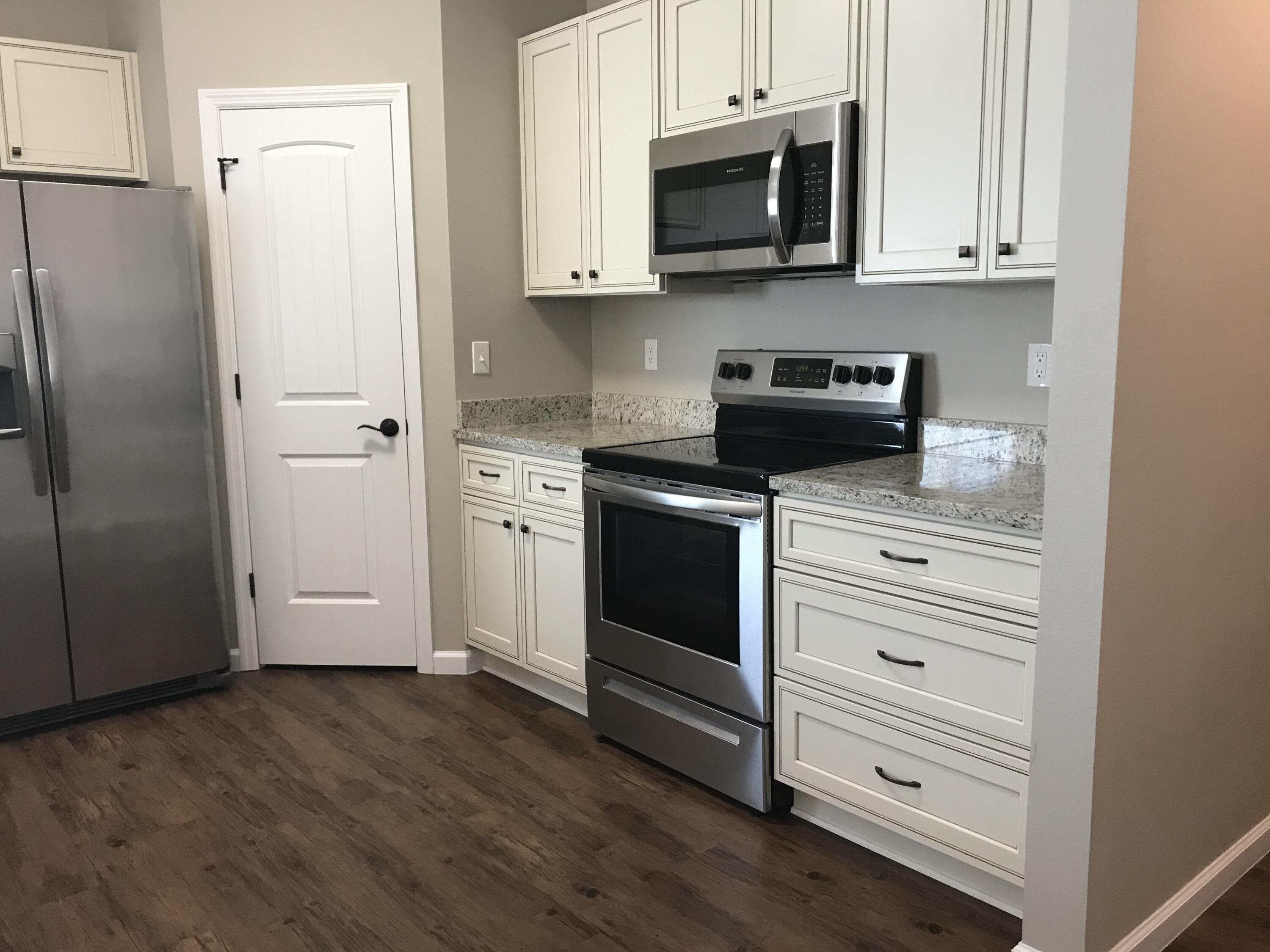 240 Dixie Street Crestview, FL 32536 - Photo 4 of 20 a kitchen with stainless steel appliances white cabinets and a refrigerator