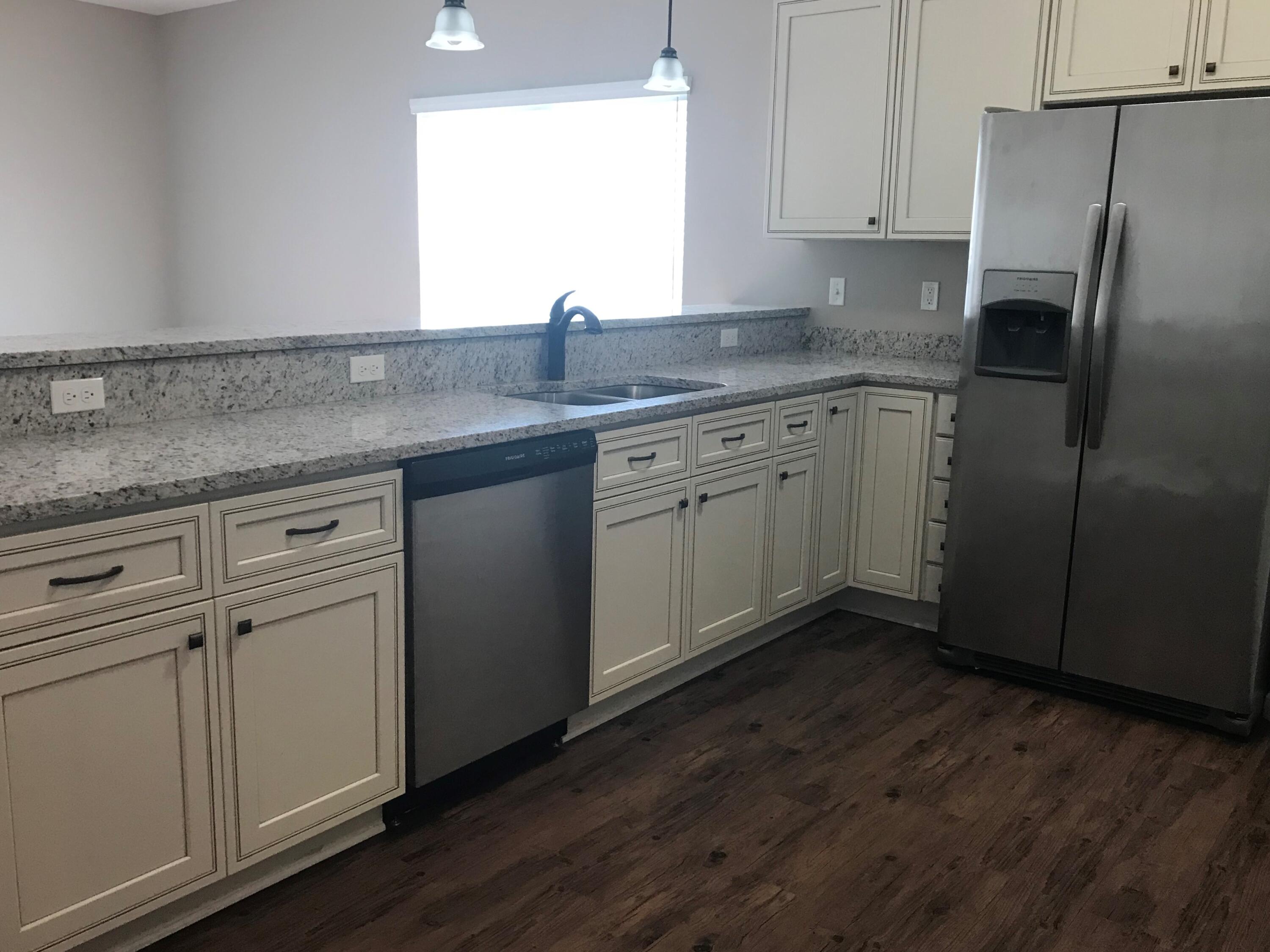 240 Dixie Street Crestview, FL 32536 - Photo 5 of 20 a kitchen with stainless steel appliances granite countertop a sink a stove a refrigerator and cabinets