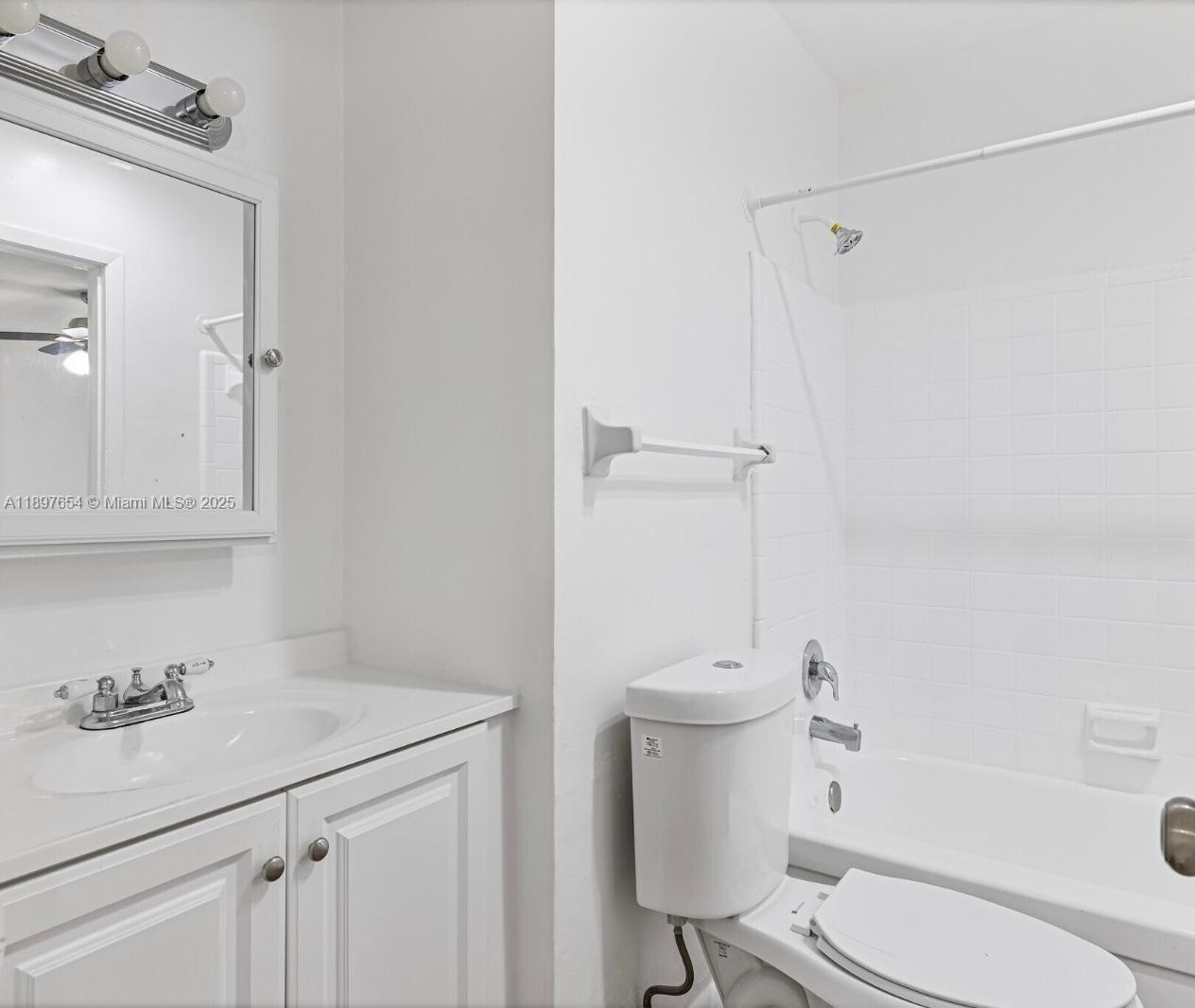 5990 Northeast 18th Avenue, Unit 505 Fort Lauderdale, FL 33334 - Photo 5 of 14 a bathroom with a sink a toilet and shower