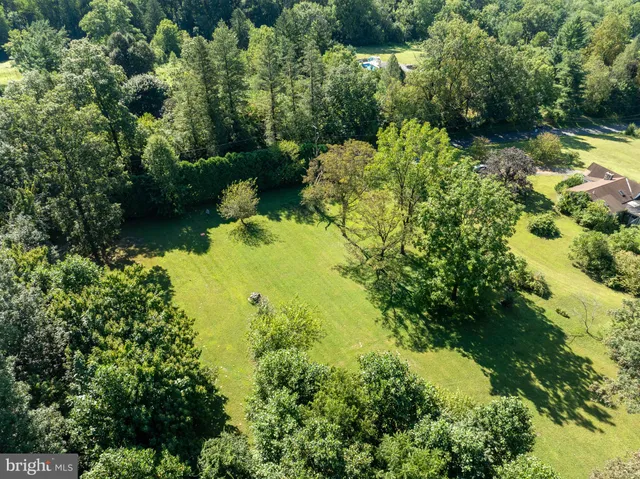 an aerial view of residential house with swimming pool and green space