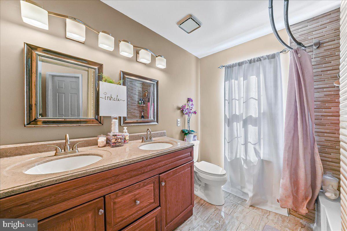 9 Corralberry Road Newark, DE 19702 - Photo 20 of 37 a bathroom with a double vanity sink toilet and a mirror