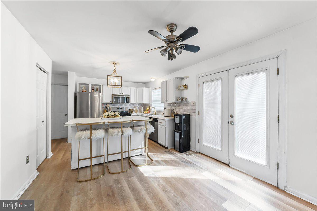 9 Corralberry Road Newark, DE 19702 - Photo 9 of 37 a kitchen with stainless steel appliances a white cabinets and wooden floor