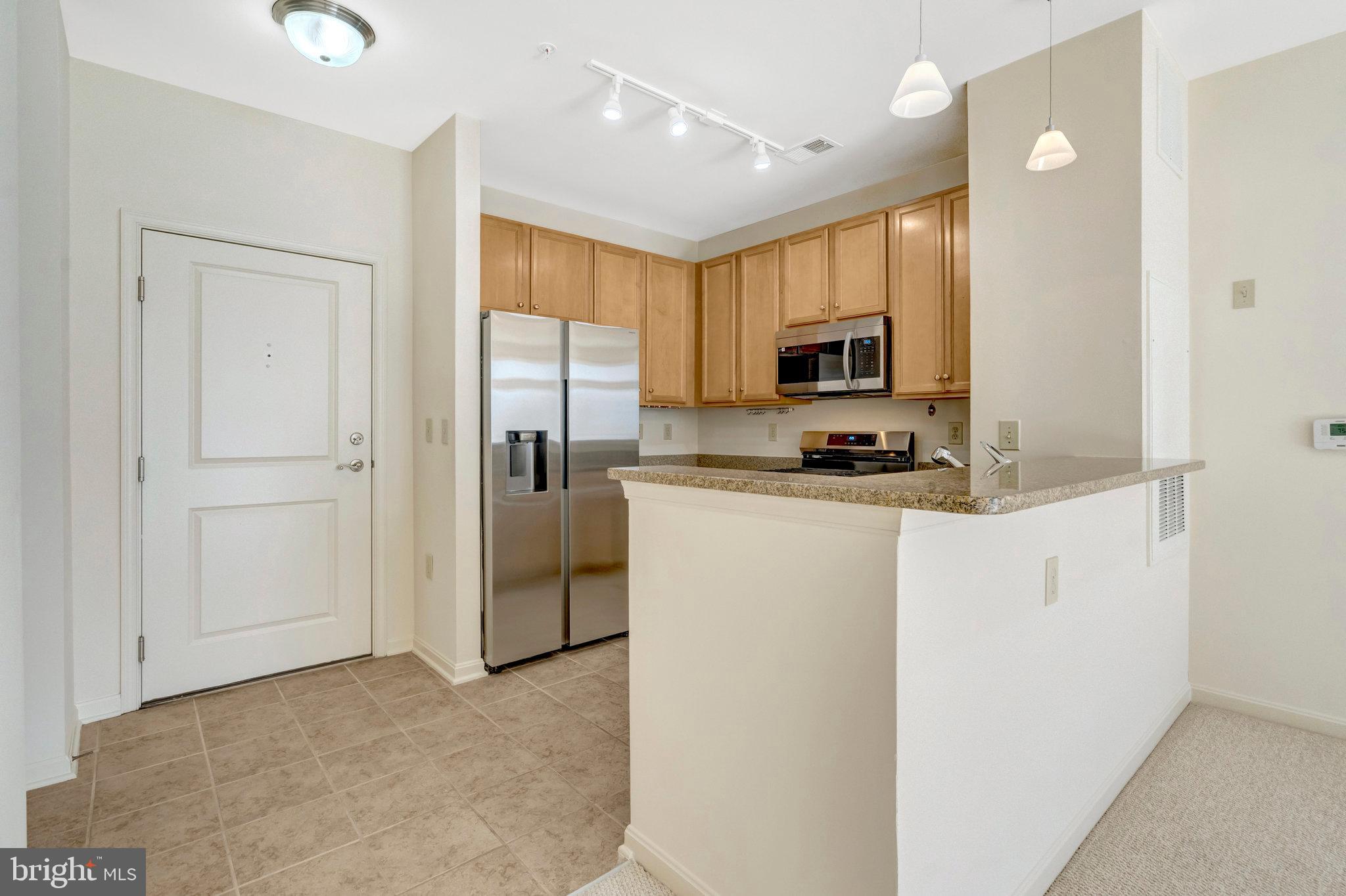 2665 Prosperity Avenue, Unit 345 Fairfax, VA 22031 - Photo 5 of 33 a kitchen with cabinets and a refrigerator