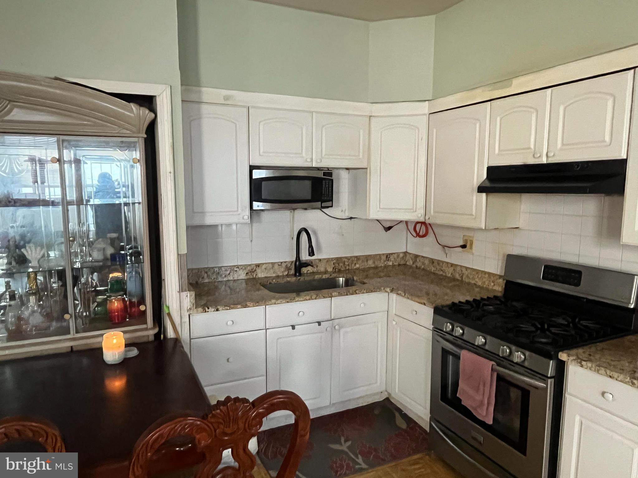 5726 Old 2nd Street Philadelphia, PA 19120 - Photo 3 of 21 a kitchen with granite countertop a sink a stove and cabinets