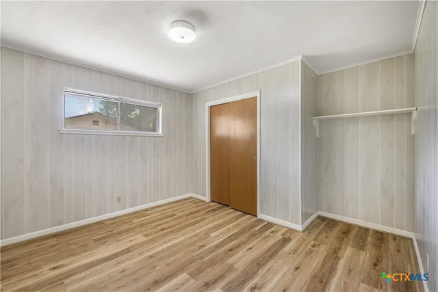 a view of empty room with wooden floor