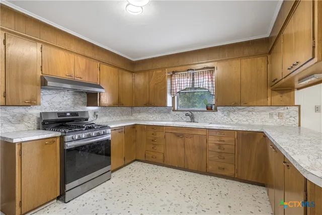 a kitchen with stainless steel appliances granite countertop a sink stove and cabinets