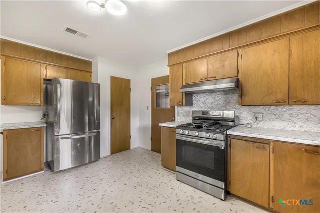 a kitchen with a stove sink and refrigerator