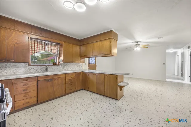 a kitchen with a sink cabinets and window