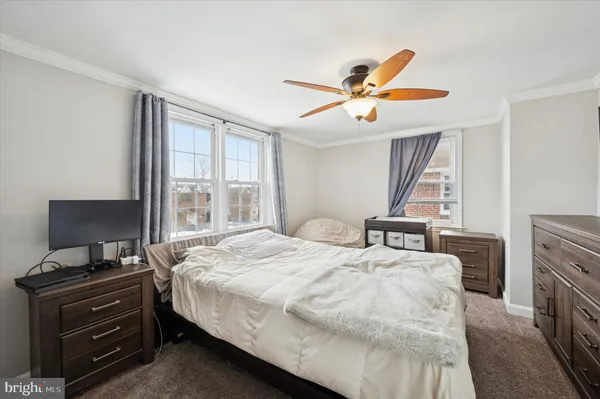 a bedroom with a bed and a flat tv screen on a dresser